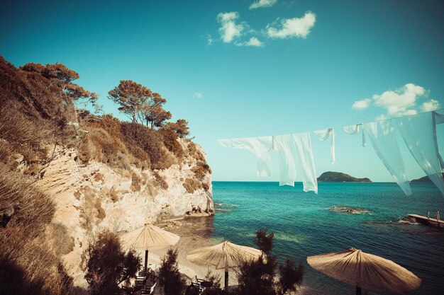 Rangée de parasols de paille et de salons de plage Zakynthos Grèce