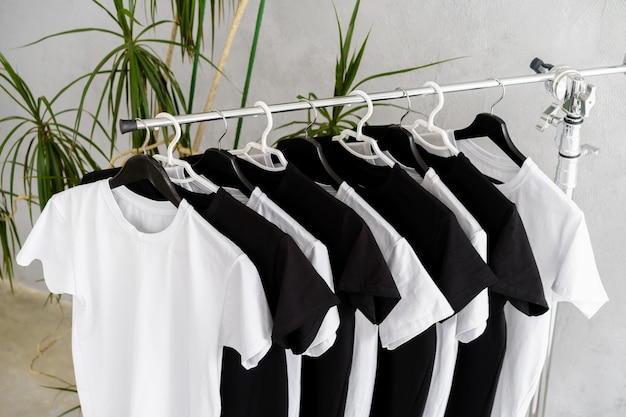 Rangée de t-shirts noirs et blancs accrochés au rack