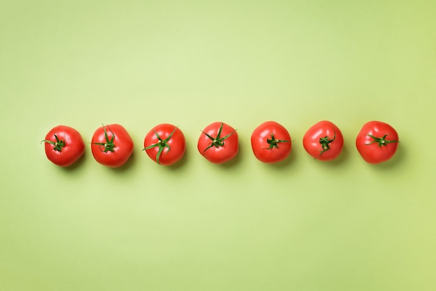 Rangée de tomates rouges fraîches. Design minimal. Concept de plats végétariens, végétaliens, d&#39;aliments biologiques et alcalins