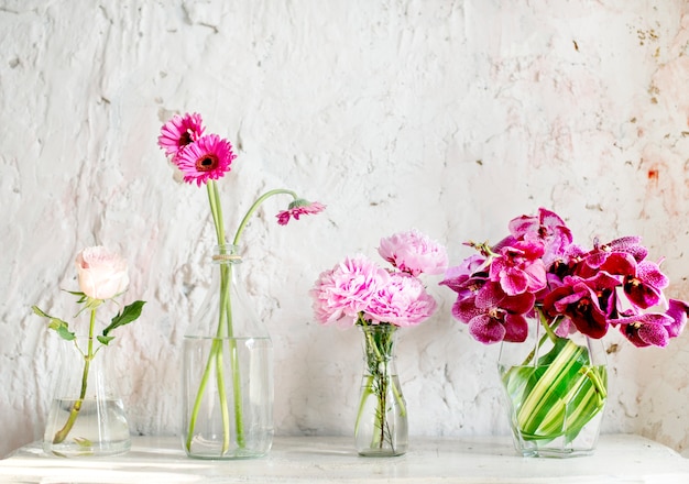 Une rangée de vases à fleurs roses