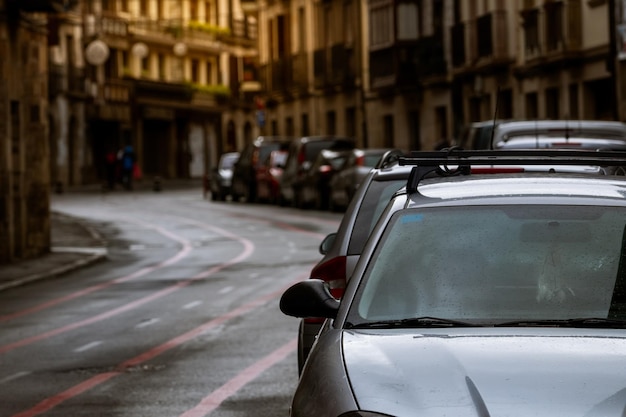 Rangée de voitures garées le long de la rue et de vieux bâtiments dans la ville d'Europe Beaucoup de voitures garées sur la route