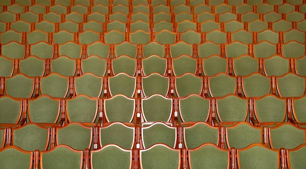 des rangées de chaises vertes dans un auditorium de théâtre