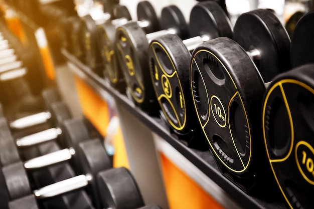 Photo rangées d'haltères dans la salle de gym