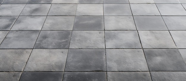 Des rangées et des lignes de carreaux de trottoir carrés de couleur grise se trouvent sur les sols à l'extérieur ou