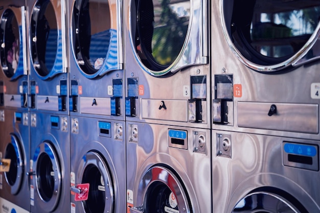 Photo rangées de machines à laver industrielles dans la grande laverie automatique