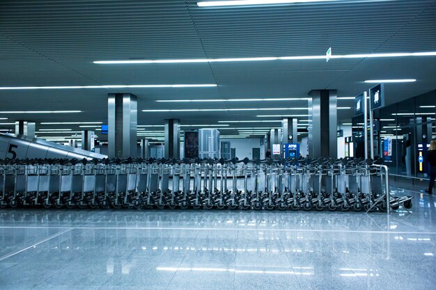 Des rangées de paniers à bagages dans le terminal de l'aéroport