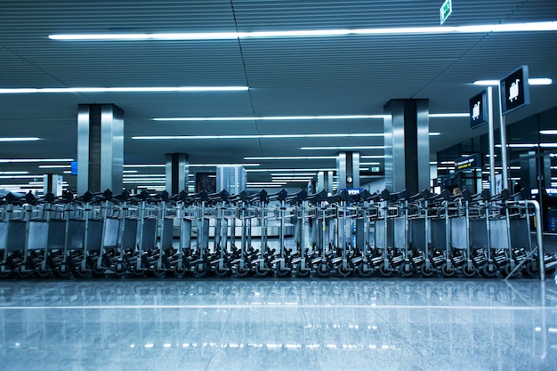 Des rangées de paniers à bagages dans le terminal de l'aéroport.