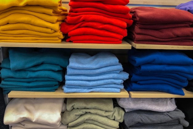 Rangées de vêtements colorés pliés dans un magasin