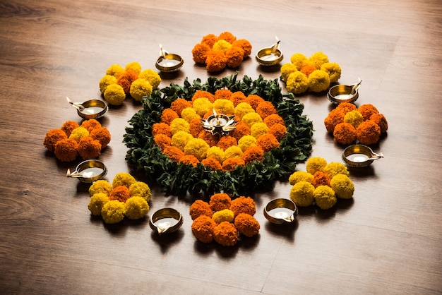 Rangoli de fleurs pour le festival de Diwali ou de Pongal à base de fleurs de souci ou de Zendu et de pétales de rose sur fond maussade ou blanc, mise au point sélective