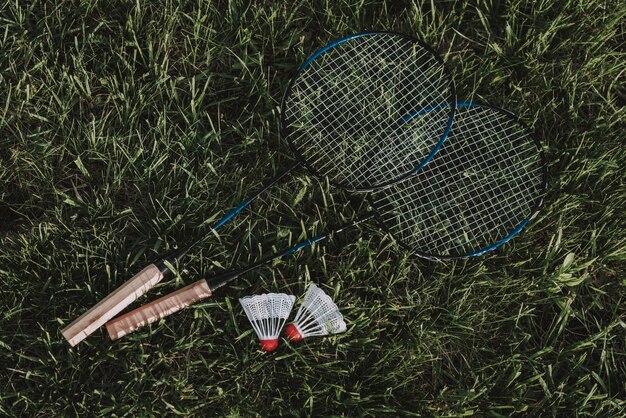 Raquette de badminton et volant sur de l'herbe.