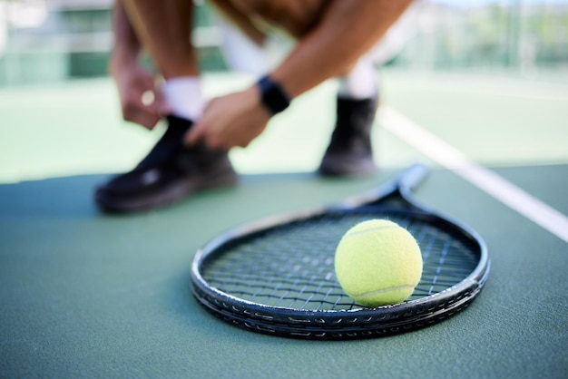 Raquette de balle de tennis et chaussures d'homme sur le court de tennis se préparant pour un match de compétition ou un match Exercice de fitness et joueur de tennis se préparant pour l'entraînement ou l'entraînement à l'extérieur sur le terrain