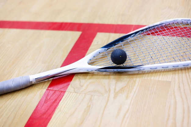 raquette de squash et balle sur le fond en bois