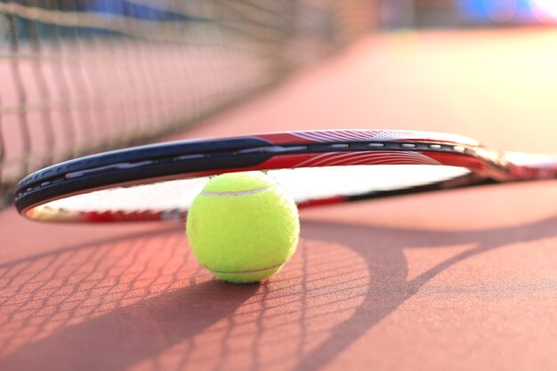 Raquette de tennis et balle sur court de tennis.