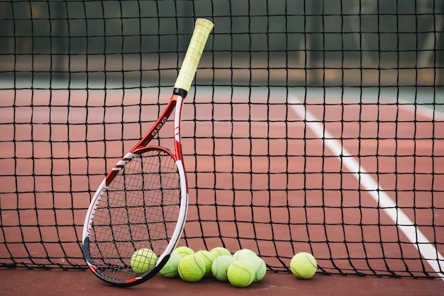 Raquette de tennis et balles sur un filet de tennis