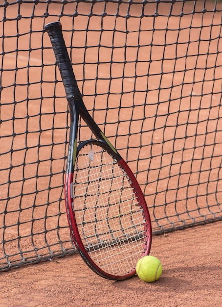 Raquette de tennis et balles sur terre battue