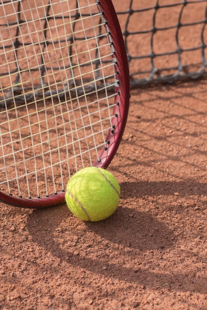 Raquette de tennis et balles sur terre battue