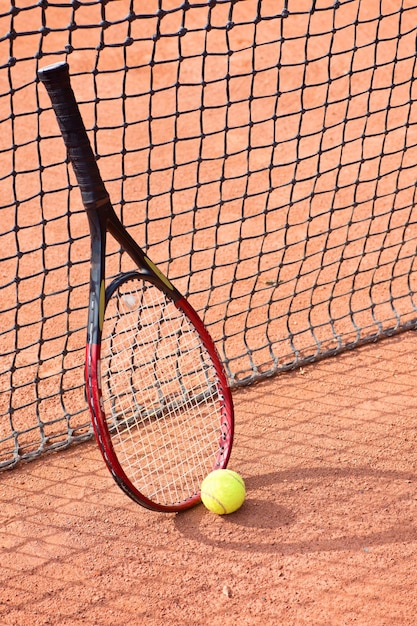 Raquette de tennis et balles sur terre battue