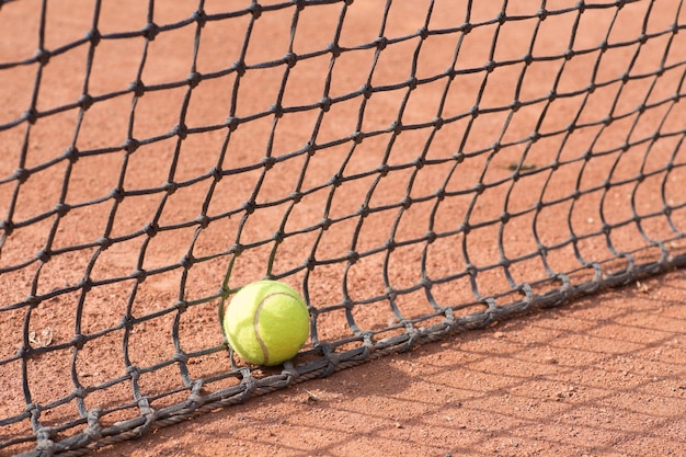 Raquette de tennis et balles sur terre battue