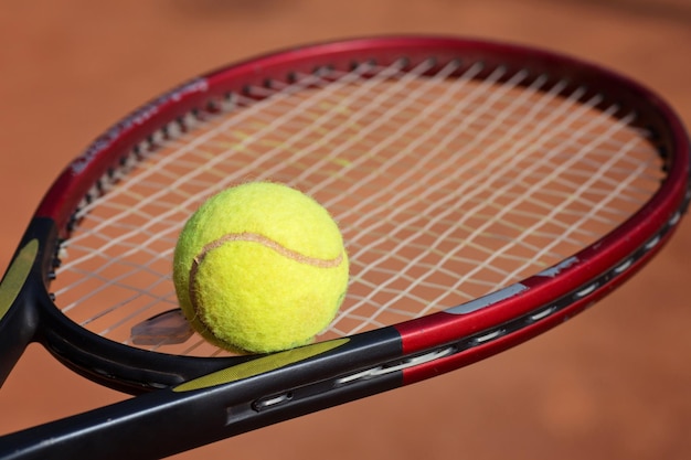 Raquette de tennis et balles sur terre battue