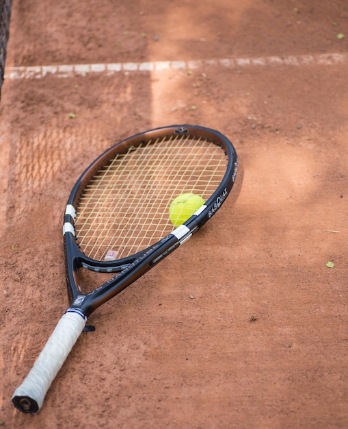 Raquette de tennis et balles sur terre battue
