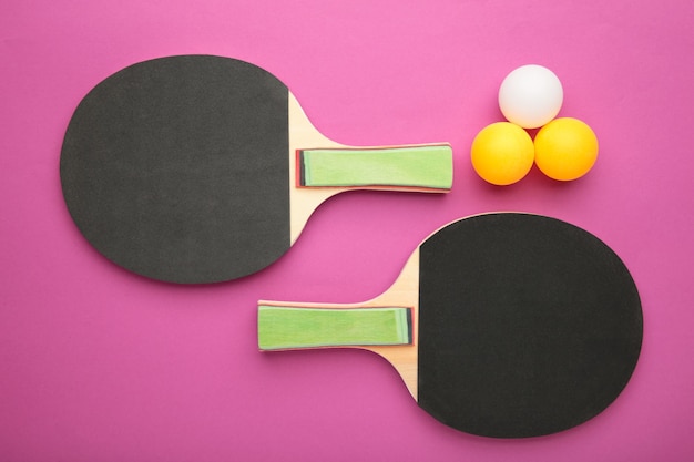 Photo raquettes et balles de ping-pong sur surface rose