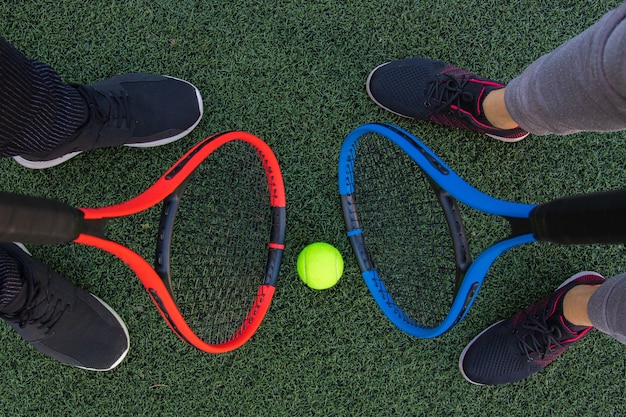 Raquettes de tennis avec balle sur fond d'herbe verte