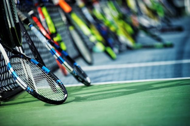 Photo raquettes de tennis ou raquettes de tennis appuyé contre le fond du court de tennis