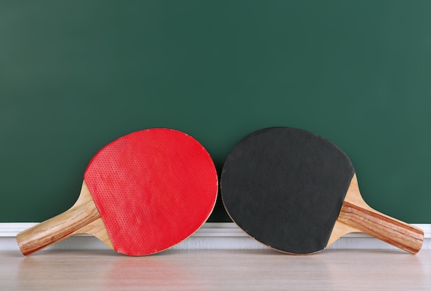 Raquettes de tennis de table sur fond de tableau noir