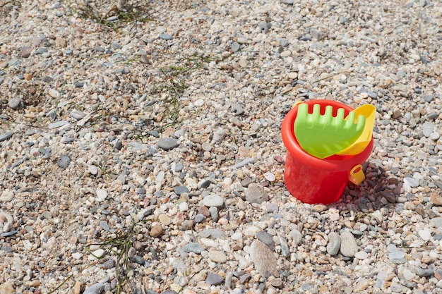 Râteau vert seau rouge et pelle de plage jaune sur le sable de la plage lors d'une journée d'été ensoleillée Vera Espagne