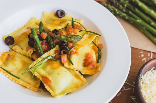 Photo ravioli aux olives, asperges et tomates se bouchent