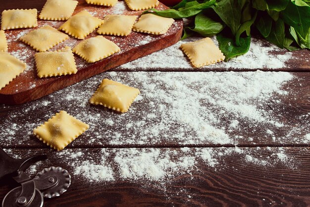 Raviolis au fromage aux épinards et au fromage avec des ingrédients sur une table en bois horizontal aucun peuple selective focus