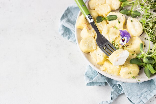 Raviolis au lait caillé servis avec microgreens et crème sure