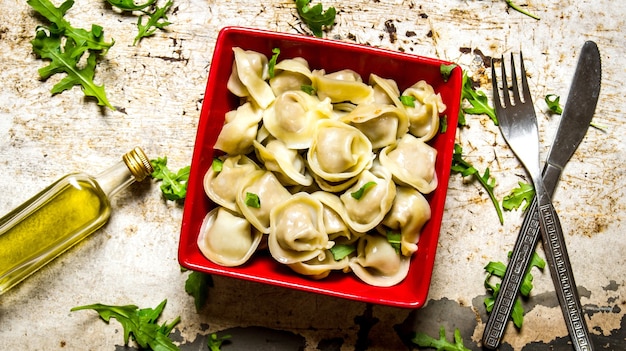 Raviolis bouillis aux herbes et huile d'olive Sur la table rustique. Vue de dessus