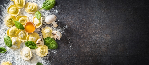 Raviolis crus aux champignons aux œufs de farine et aux épinards - Vue de dessus. Cuisine saine italienne ou méditerranéenne.