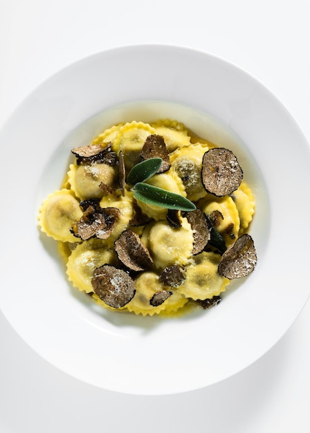 Photo raviolis italiens au parmesan au beurre et à la truffe sur le tableau blanc