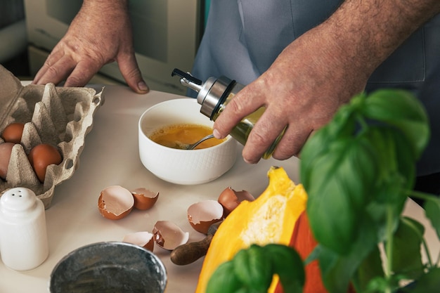 Raviolis italiens faits maison de ricotta de potiron remuant des oeufs ajoutant l'huile et le sel aux oeufs