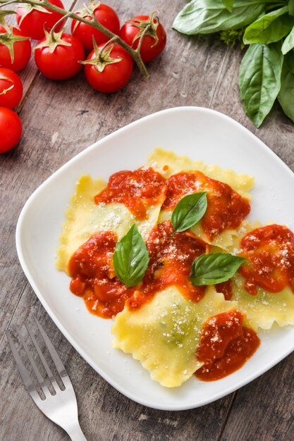 Raviolis à la sauce tomate et basilic sur fond en bois vue de dessus