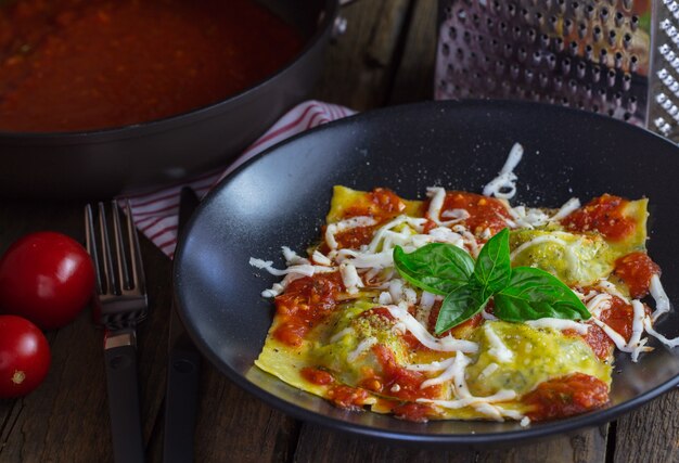 Raviolis à la sauce tomate et basilic sur noir