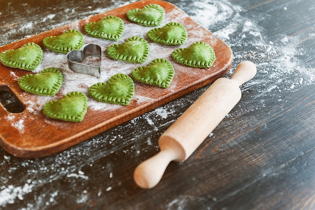 Raviolis verts en forme de coeur sur une surface en bois