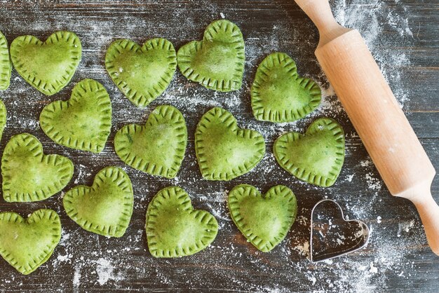 Raviolis verts en forme de coeur sur une surface en bois