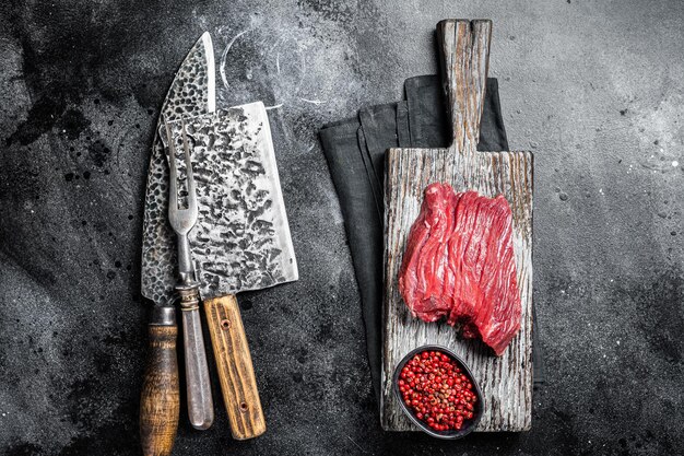 Photo raw venaison cher steak prêt pour la cuisson fond noir vue de dessus