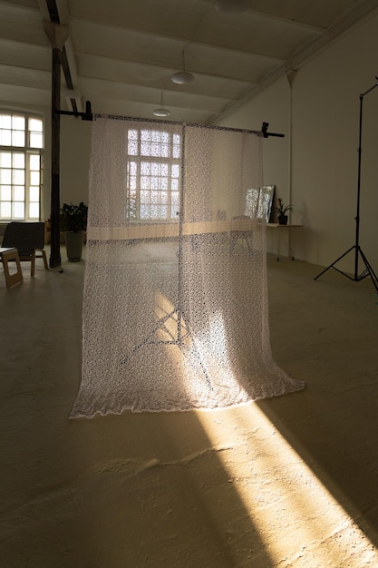 Rayon de soleil traversant le fond textile dans le studio photo avec de larges fenêtres