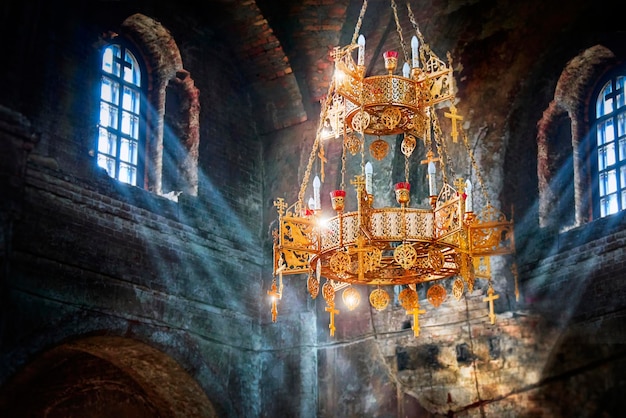 Rayons de lumière dans une ancienne église en pierre Les rayons du soleil dans un temple en pierre sombre Effets d'éclairage sur le lustre Mise au point sélective