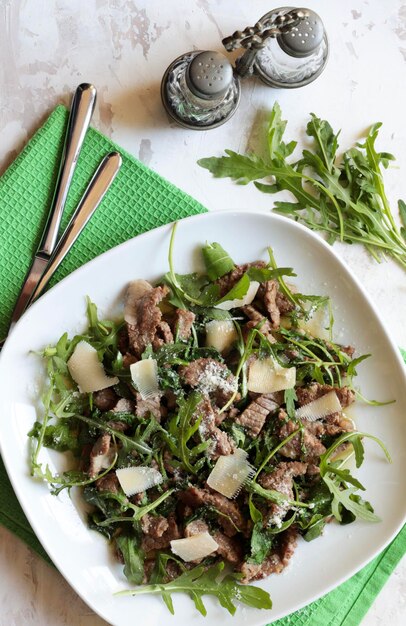 Des rayures de viande avec de la roquette et du parmesan