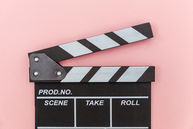 Réalisateur film vide faisant clap ou ardoise de film isolé sur fond rose