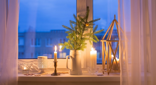 Le rebord de la fenêtre du soir de Noël avec des bougies allumées