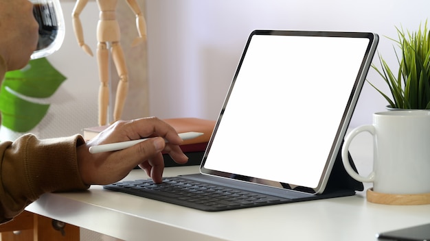 Recadrage de l&#39;homme travaillant sur une tablette et un clavier intelligent au bureau