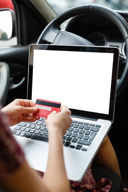 Recadrer l'image de maquette d'une femme faisant ses courses sur Internet à l'aide d'un ordinateur portable et d'informations de carte de crédit