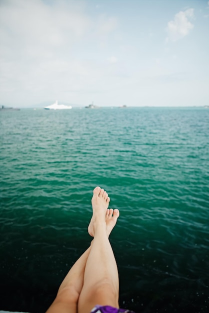 Recadrer les pieds féminins au-dessus de l'eau de mer