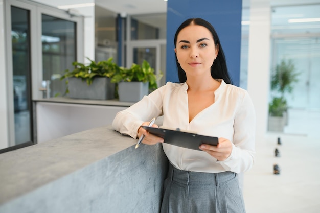 Réceptionniste femme brune travaillant à la réception du salon de beauté